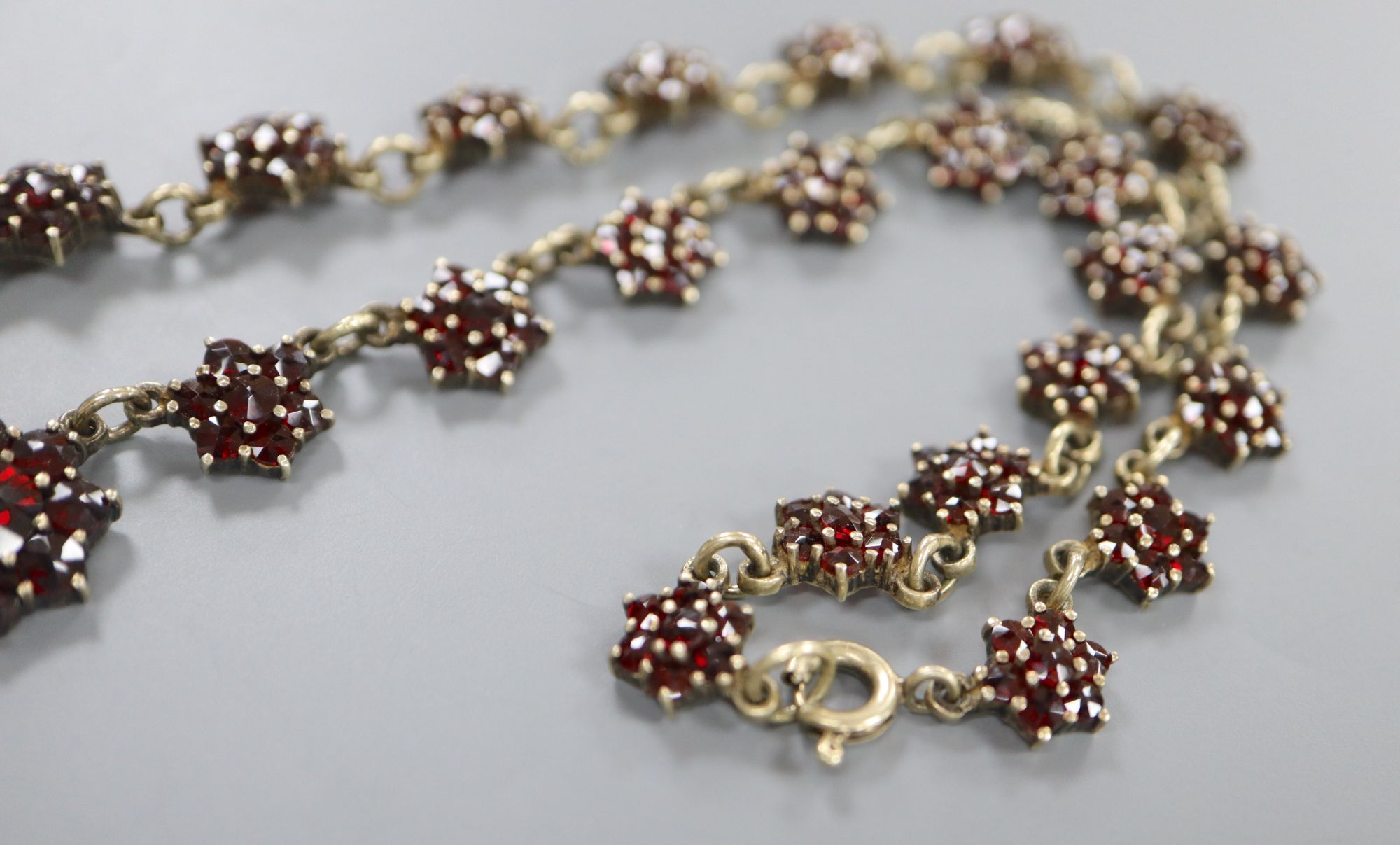 A 19th century gilt white metal and facet cut garnet set bracelet and similar necklace, 40cm.